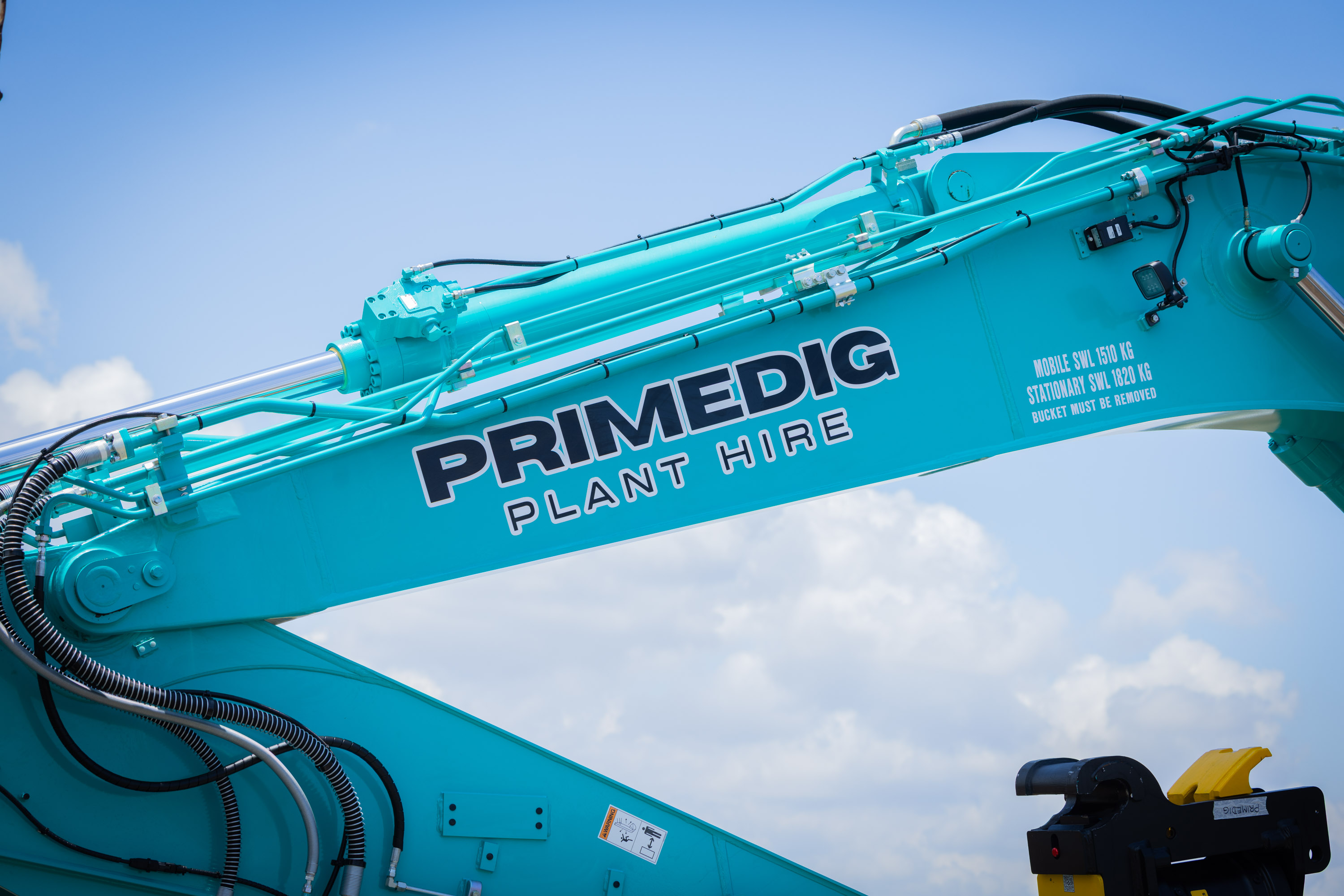 PrimeDig Plant Hire branding on the boom of a Kobelco excavator